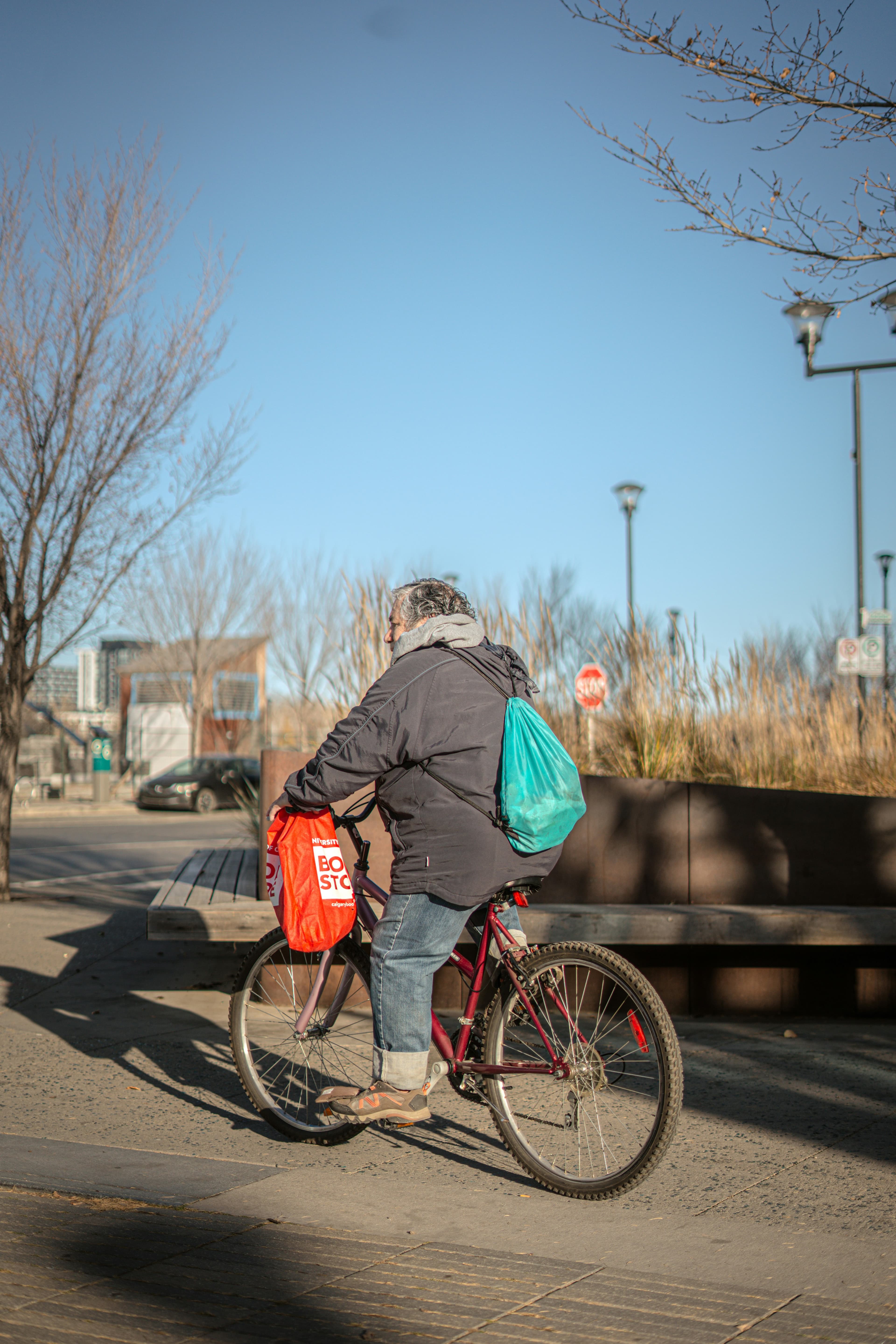 A volunteer riding a bicycle loaded with bags of food